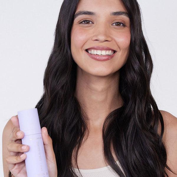 Hair by Sam McKnight Happy Endings Nourishing Balm model holding bottle